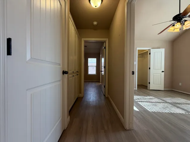 a view of a hallway with wooden floor and staircase
