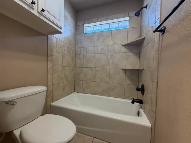 a white toilet sitting next to a bath tub