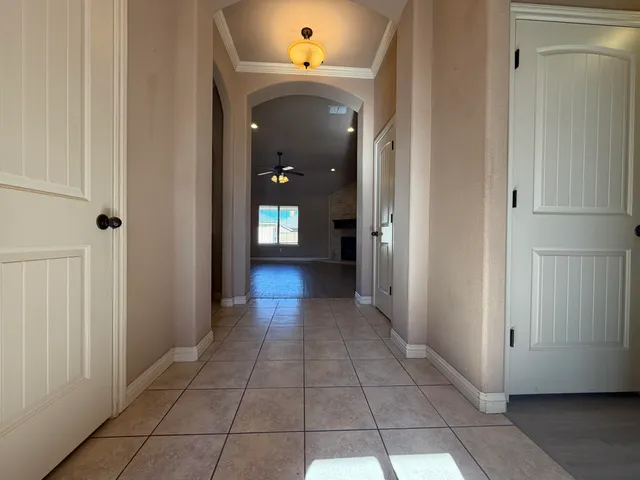 a view of a hallway with wooden floor and a living room