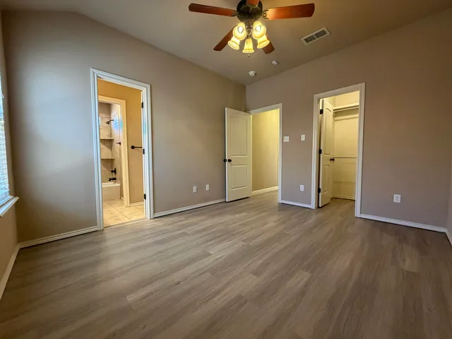 an empty room with wooden floor and chandelier