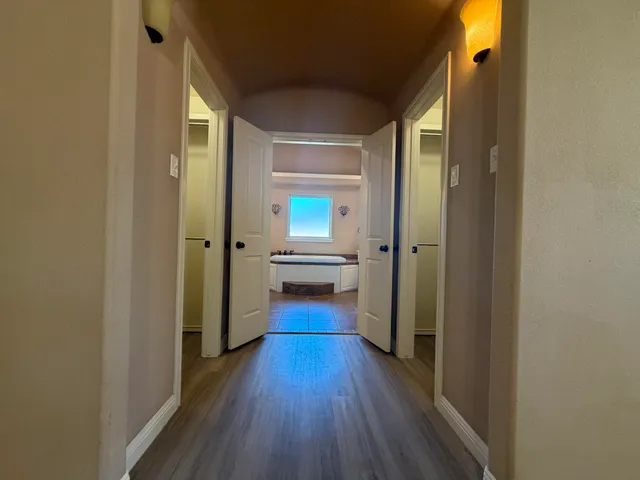 a view of a hallway with wooden floor