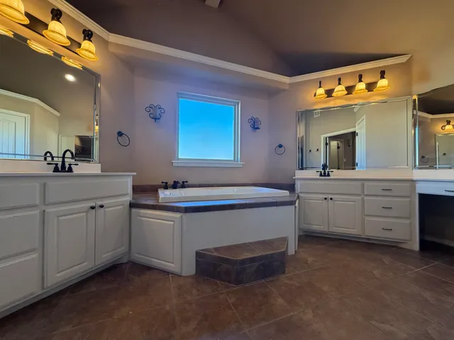 a spacious bathroom with a double vanity sink a mirror and a bathtub