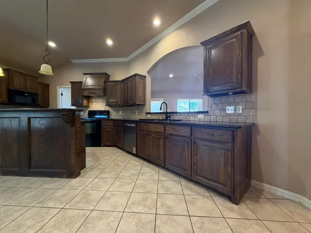 a kitchen with stainless steel appliances granite countertop a refrigerator and a stove top oven