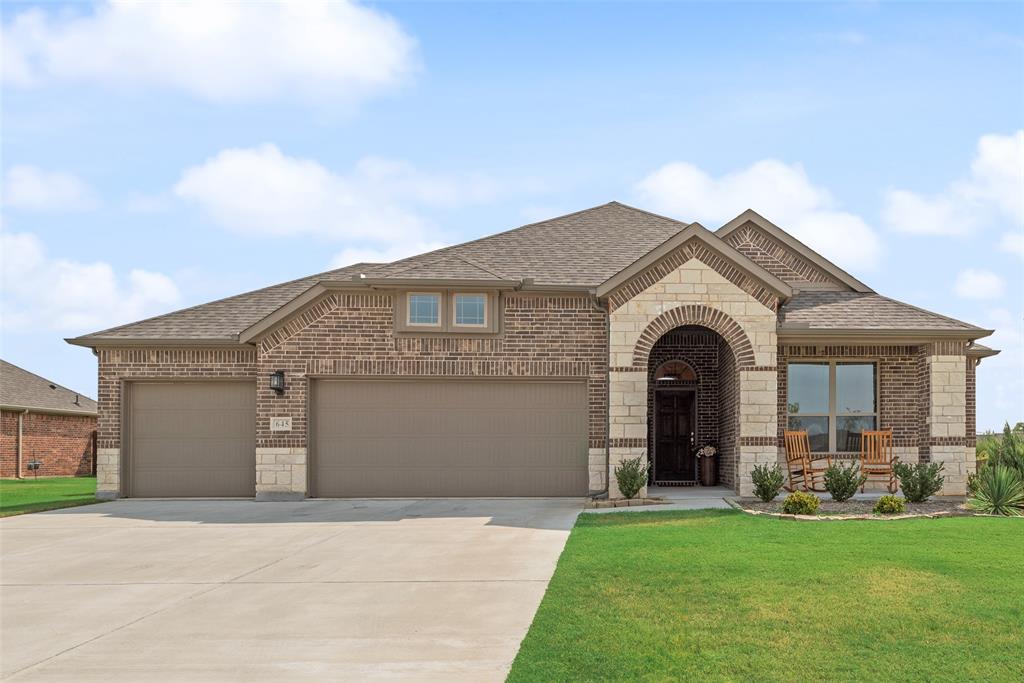 645 Mb Way South Pilot Point, TX 76258 - Photo 1 of 37 Beautiful curb appeal with a brick-and-stone exterior, inviting covered entry, manicured landscaping, and a spacious three-car garage.
