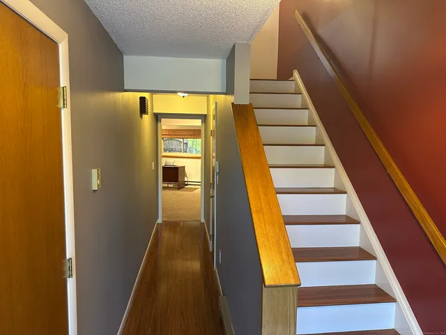 a view of entryway and hall with wooden floor