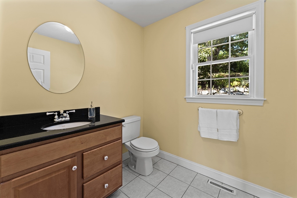 77 Hawthorne Road Waltham, MA 02451 - Photo 12 of 27 a bathroom with a granite countertop sink a toilet and a mirror