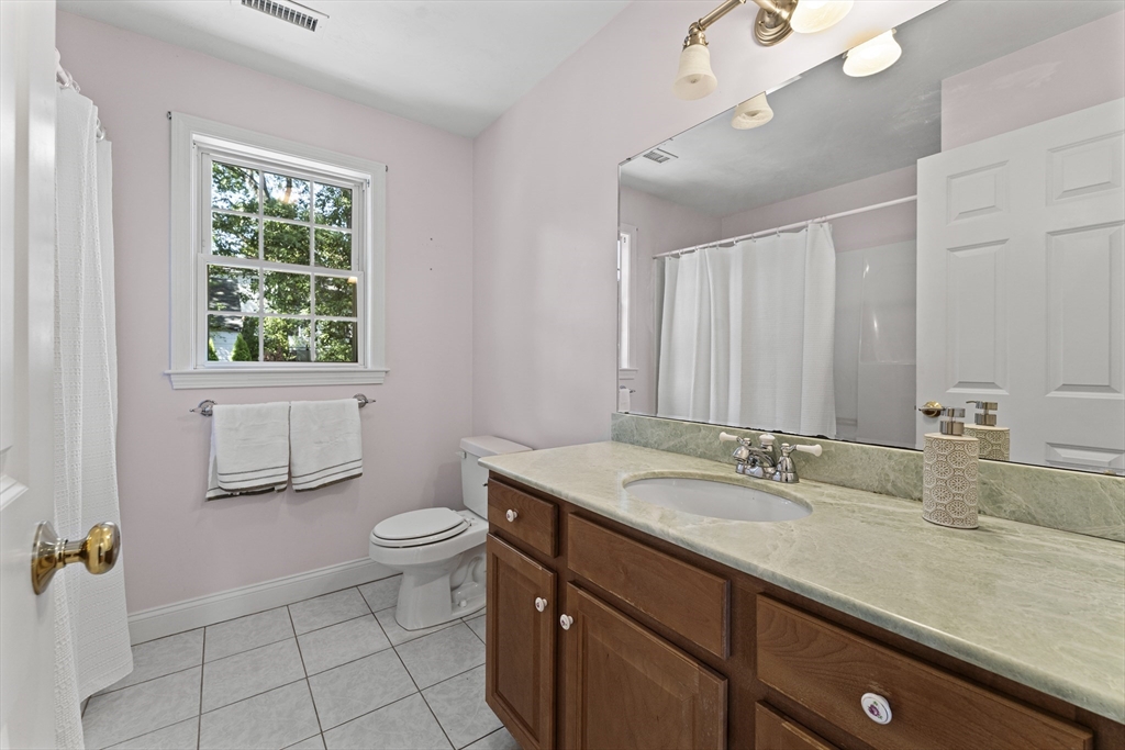 77 Hawthorne Road Waltham, MA 02451 - Photo 20 of 27 a bathroom with a granite countertop sink a toilet a mirror and window