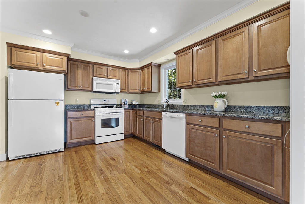 77 Hawthorne Road Waltham, MA 02451 - Photo 10 of 27 a kitchen with granite countertop wooden floors stainless steel appliances a sink and a window