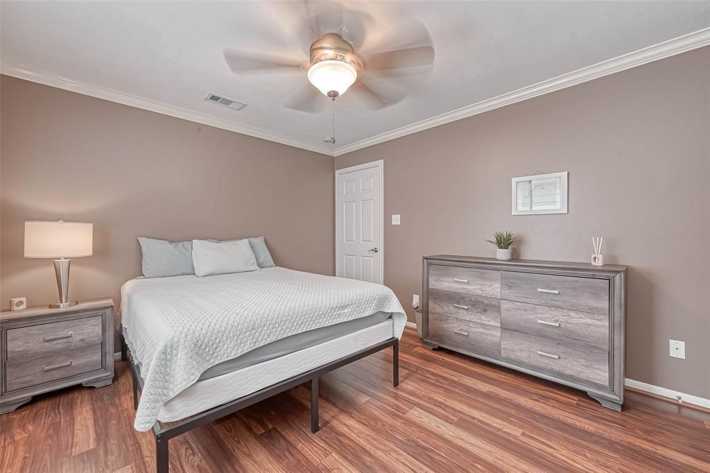 1204 Andrews Street Houston, TX 77019 - Photo 8 of 15 a bedroom with a bed and wooden floor