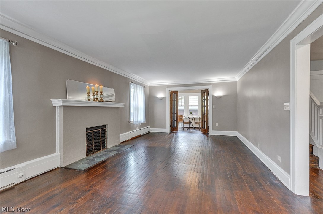 2972 Yorkshire Road Cleveland Heights, OH 44118 - Photo 6 of 44 Spacious living area featuring rich wood-finish flooring, a decorative fireplace with a hearth, crown molding, and a neutral wall palette