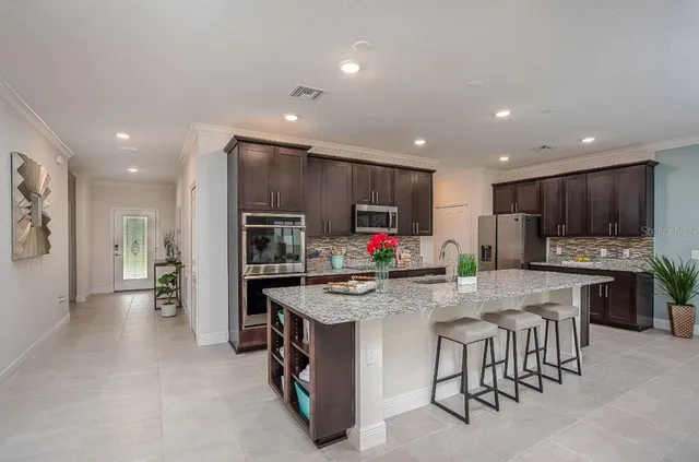 a kitchen with stainless steel appliances granite countertop a refrigerator and a stove top oven