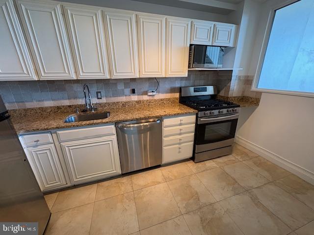 1200 North Nash Street, Unit 1155 Arlington, VA 22209 - Photo 11 of 23 a kitchen with stainless steel appliances granite countertop a stove a sink and a microwave
