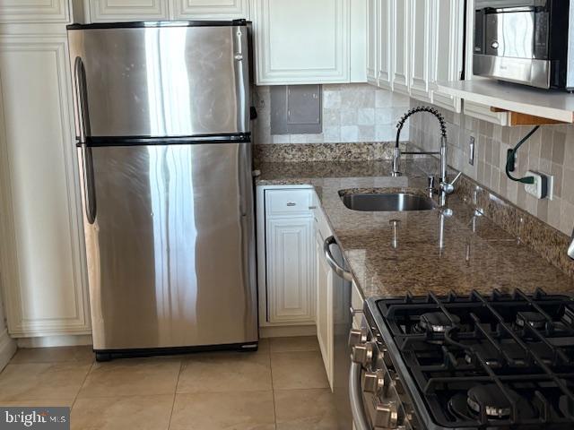 1200 North Nash Street, Unit 1155 Arlington, VA 22209 - Photo 12 of 23 a kitchen with granite countertop a refrigerator and a sink
