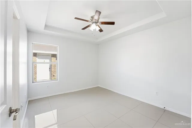 an empty room with a window and ceiling fan