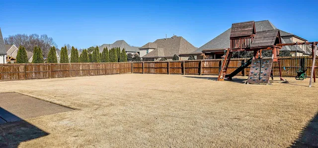 a view of swimming pool with a yard and wooden fence