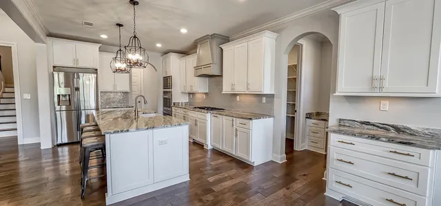 a kitchen with white cabinets and stainless steel appliances