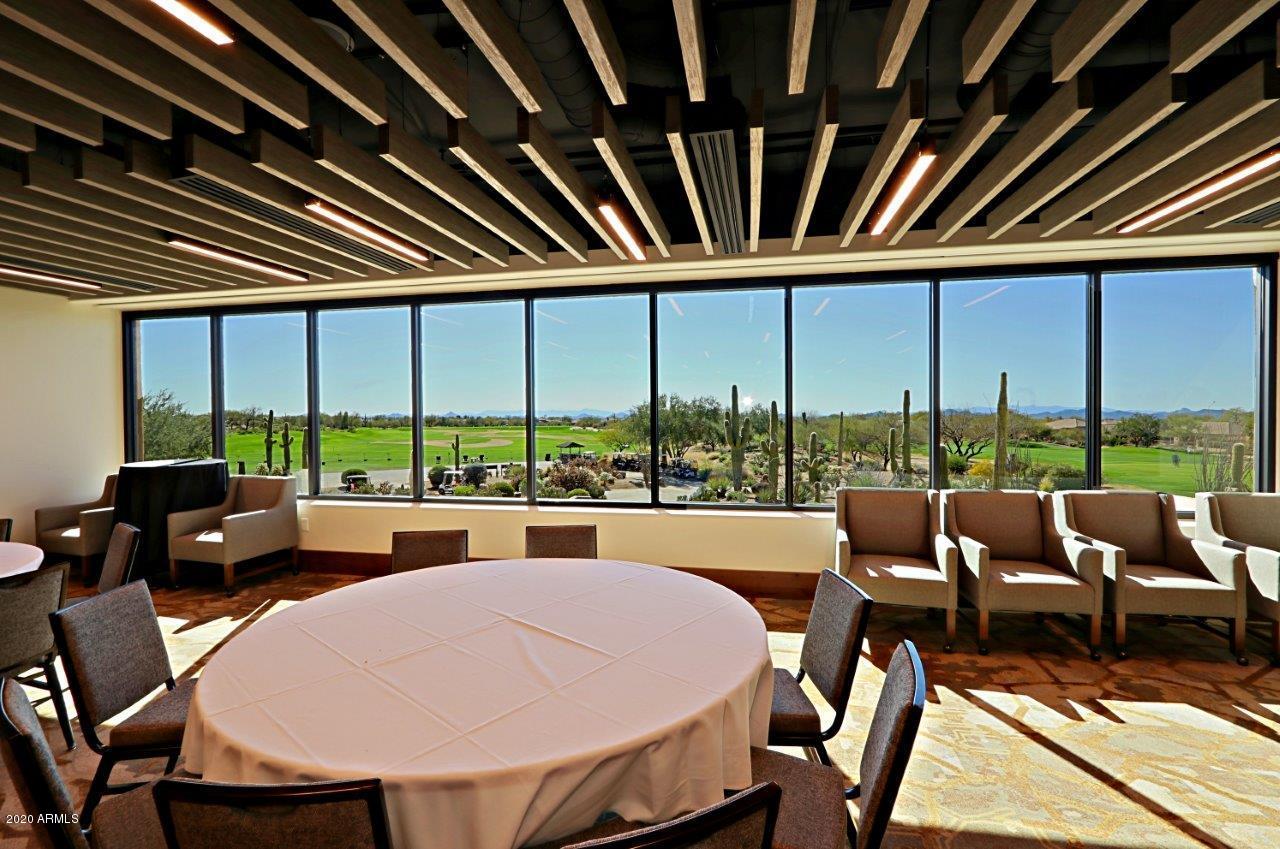 6803 East Eagle Feather Road Scottsdale, AZ 85266 - Photo 40 of 67 a dining room with furniture a flat screen tv and a large window
