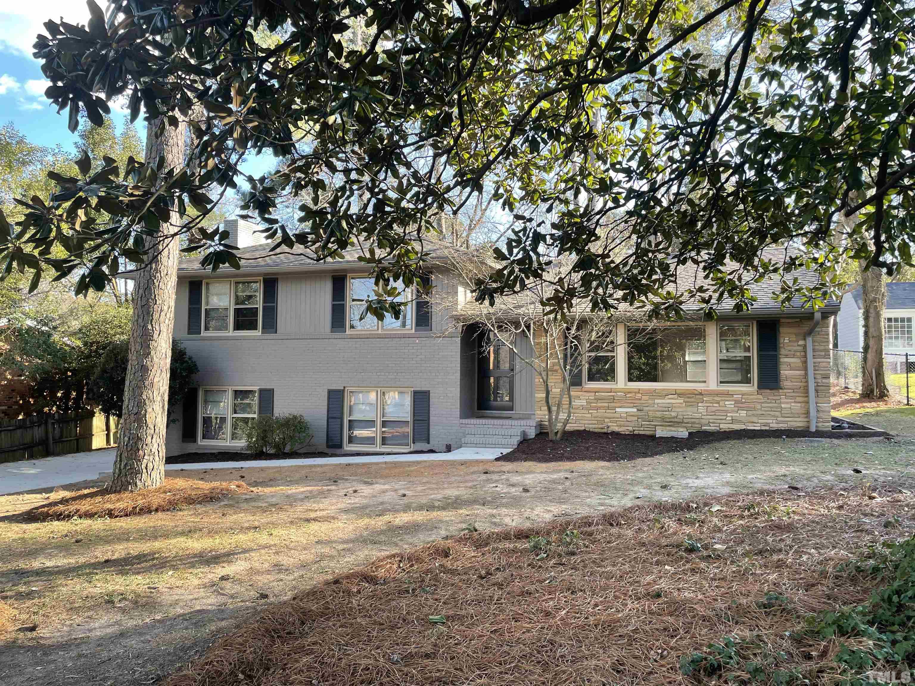 a view of a house with a tree in front