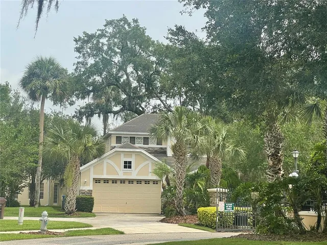 a white house that has a tree in front of it