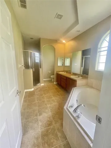 a large bathroom with a tub sink and mirror