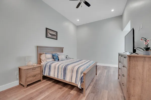 a bedroom with a bed and a flat tv screen on dresser