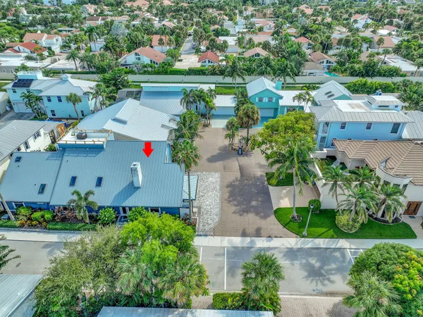 an aerial view of residential houses with outdoor space and trees