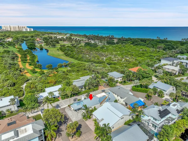 an aerial view of residential houses with outdoor space and trees