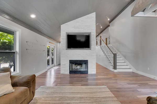 a living room with furniture a fireplace and a flat screen tv