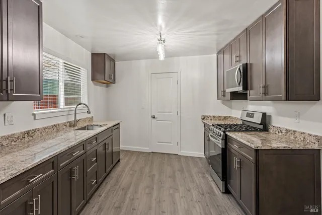a kitchen with a sink stove top oven and refrigerator