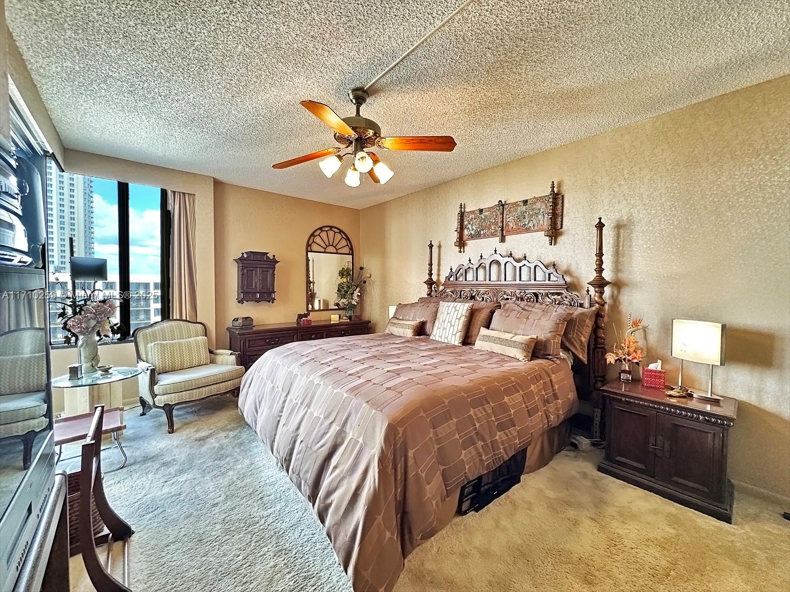 520 Brickell Key Drive, Unit A1802 Miami, FL 33131 - Photo 14 of 35 a bedroom with a bed and a chandelier