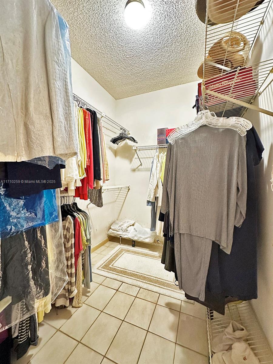 520 Brickell Key Drive, Unit A1802 Miami, FL 33131 - Photo 17 of 35 a view of walk in closet with clothes and shoes