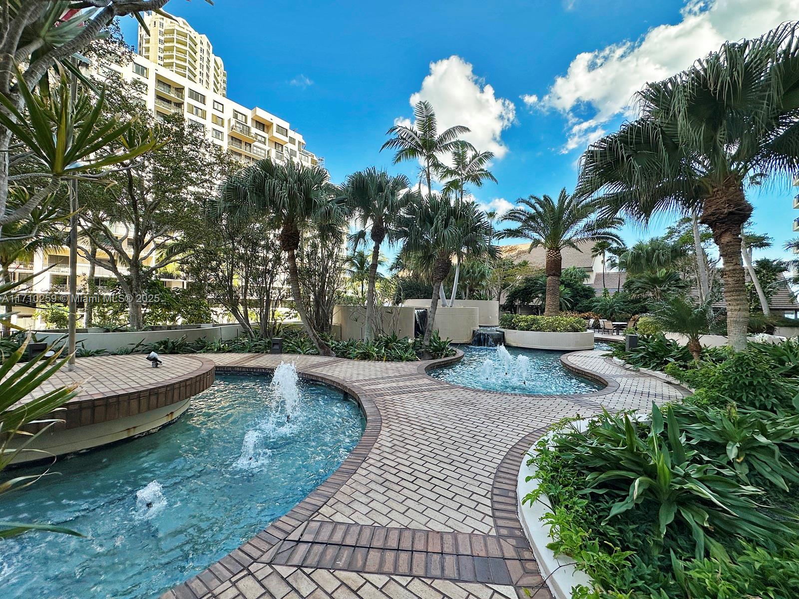 520 Brickell Key Drive, Unit A1802 Miami, FL 33131 - Photo 29 of 35 a view of a swimming pool with a patio and plants