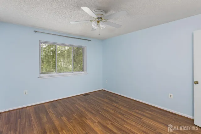 an empty room with a window and a ceiling fan