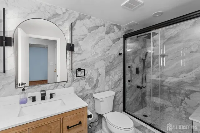 a bathroom with a sink a toilet and shower