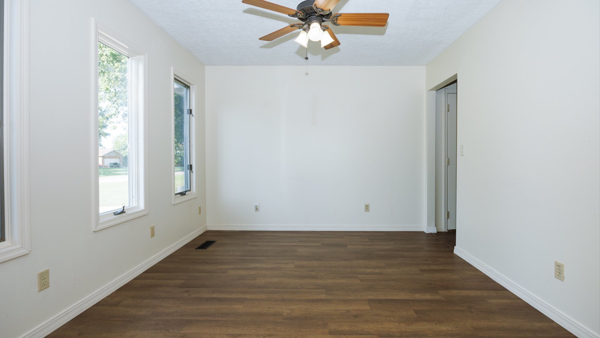 800 West Hamilton Street Atlanta, IL 61723 - Photo 12 of 44 an empty room with wooden floor fan and windows