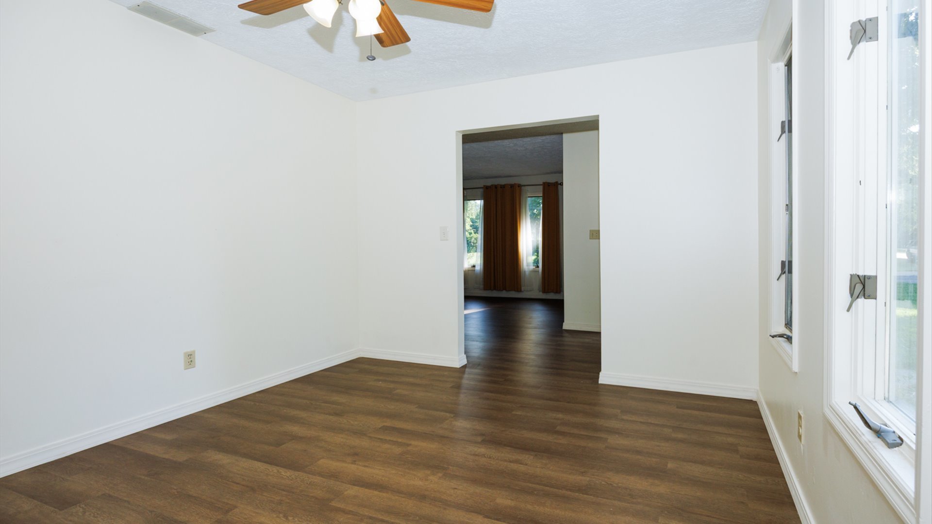 800 West Hamilton Street Atlanta, IL 61723 - Photo 13 of 44 a view of an empty room with wooden floor a ceiling fan and window