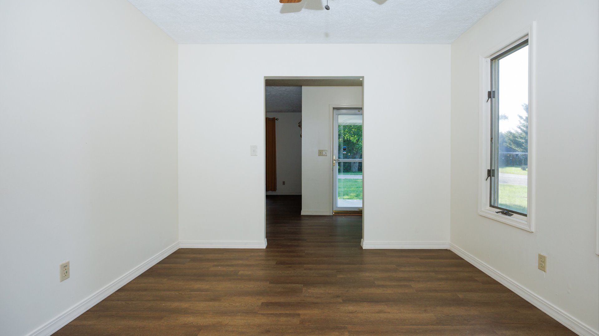 800 West Hamilton Street Atlanta, IL 61723 - Photo 14 of 44 a view of an empty room with wooden floor and a window