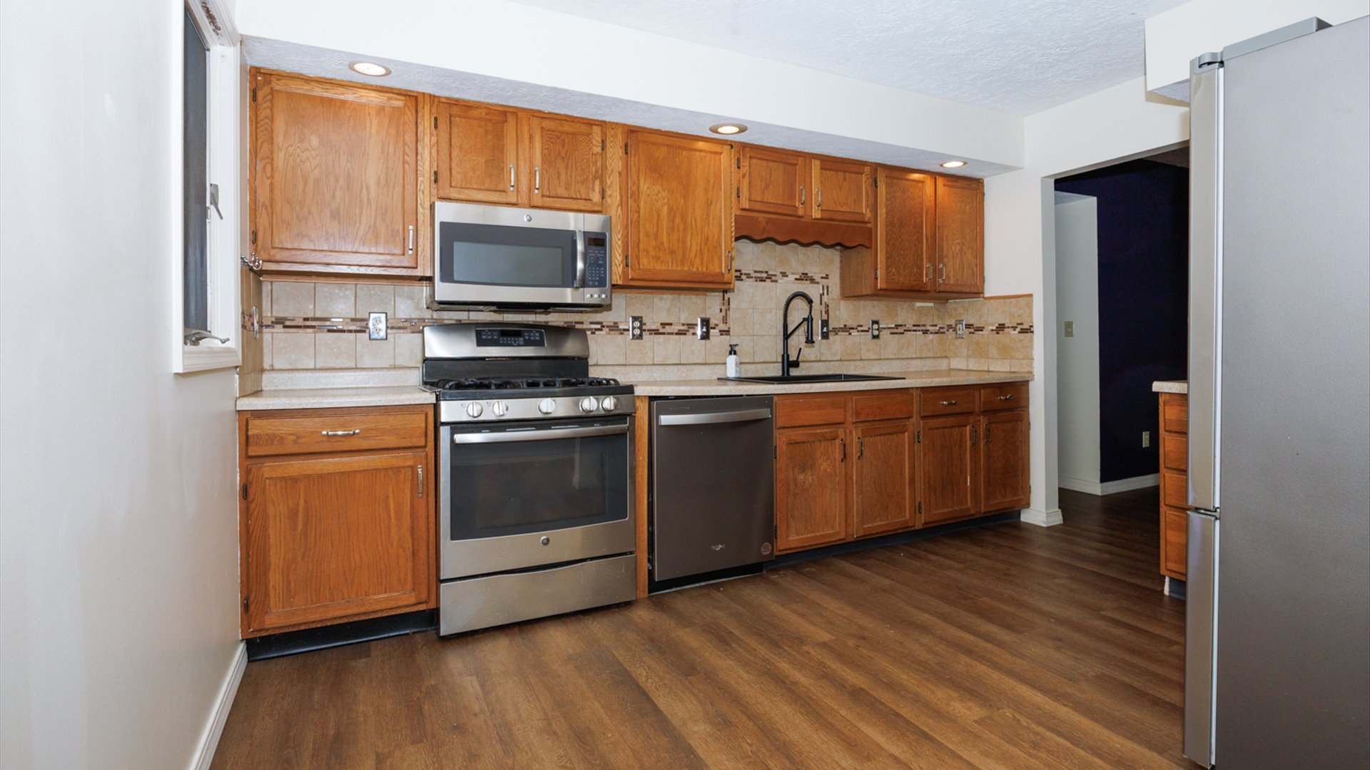 800 West Hamilton Street Atlanta, IL 61723 - Photo 15 of 44 a kitchen with a sink cabinets stainless steel appliances and a window