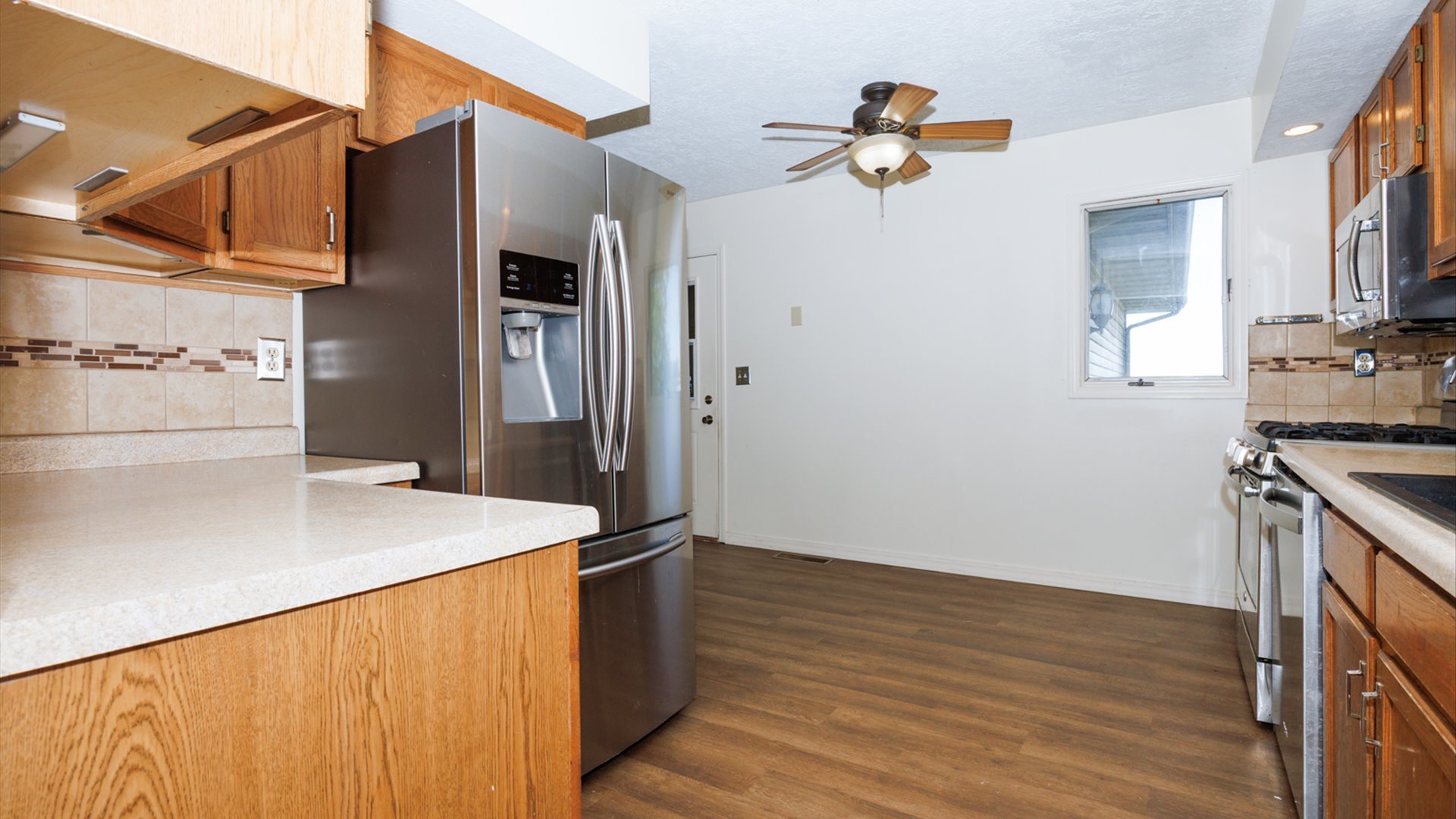 800 West Hamilton Street Atlanta, IL 61723 - Photo 19 of 44 a kitchen with stainless steel appliances granite countertop a refrigerator a stove and a wooden floors