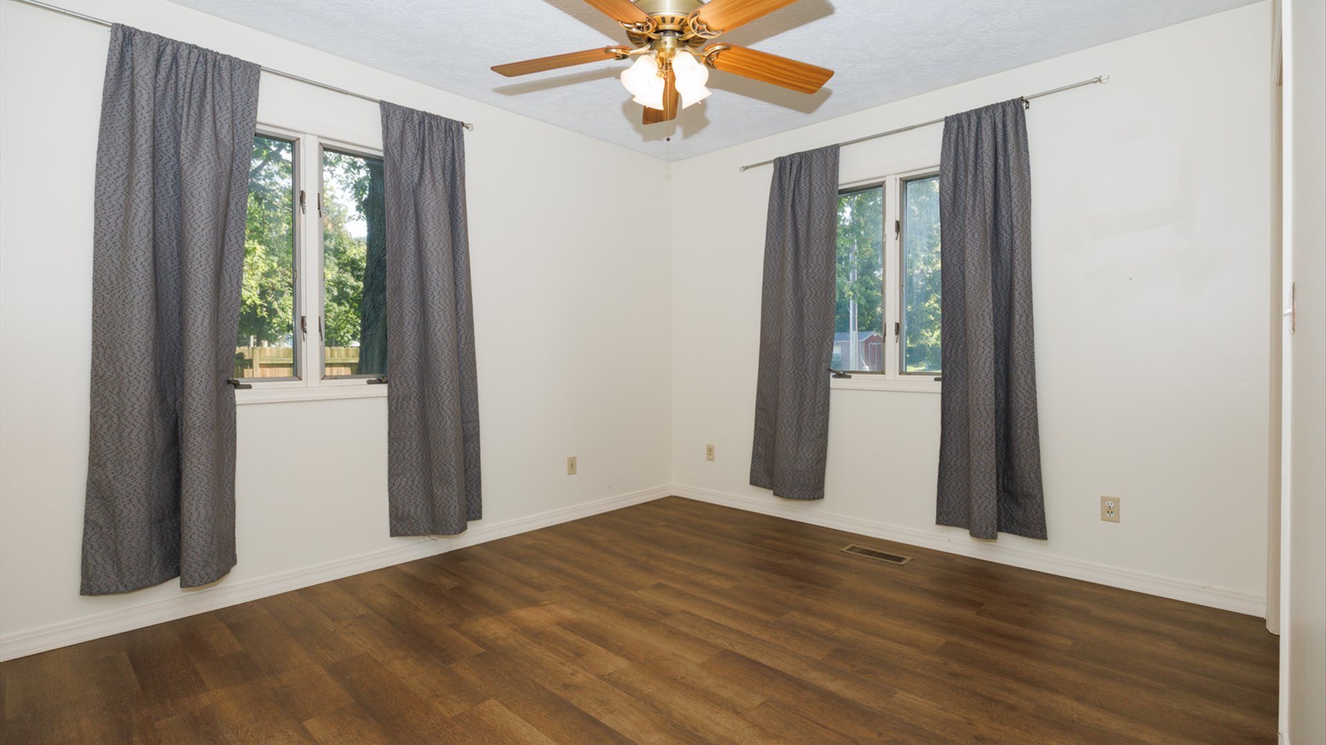 800 West Hamilton Street Atlanta, IL 61723 - Photo 25 of 44 an empty room with wooden floor fan and windows