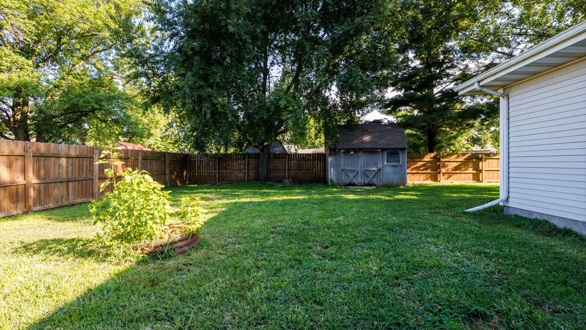800 West Hamilton Street Atlanta, IL 61723 - Photo 37 of 44 a view of a backyard with wooden fence and large trees