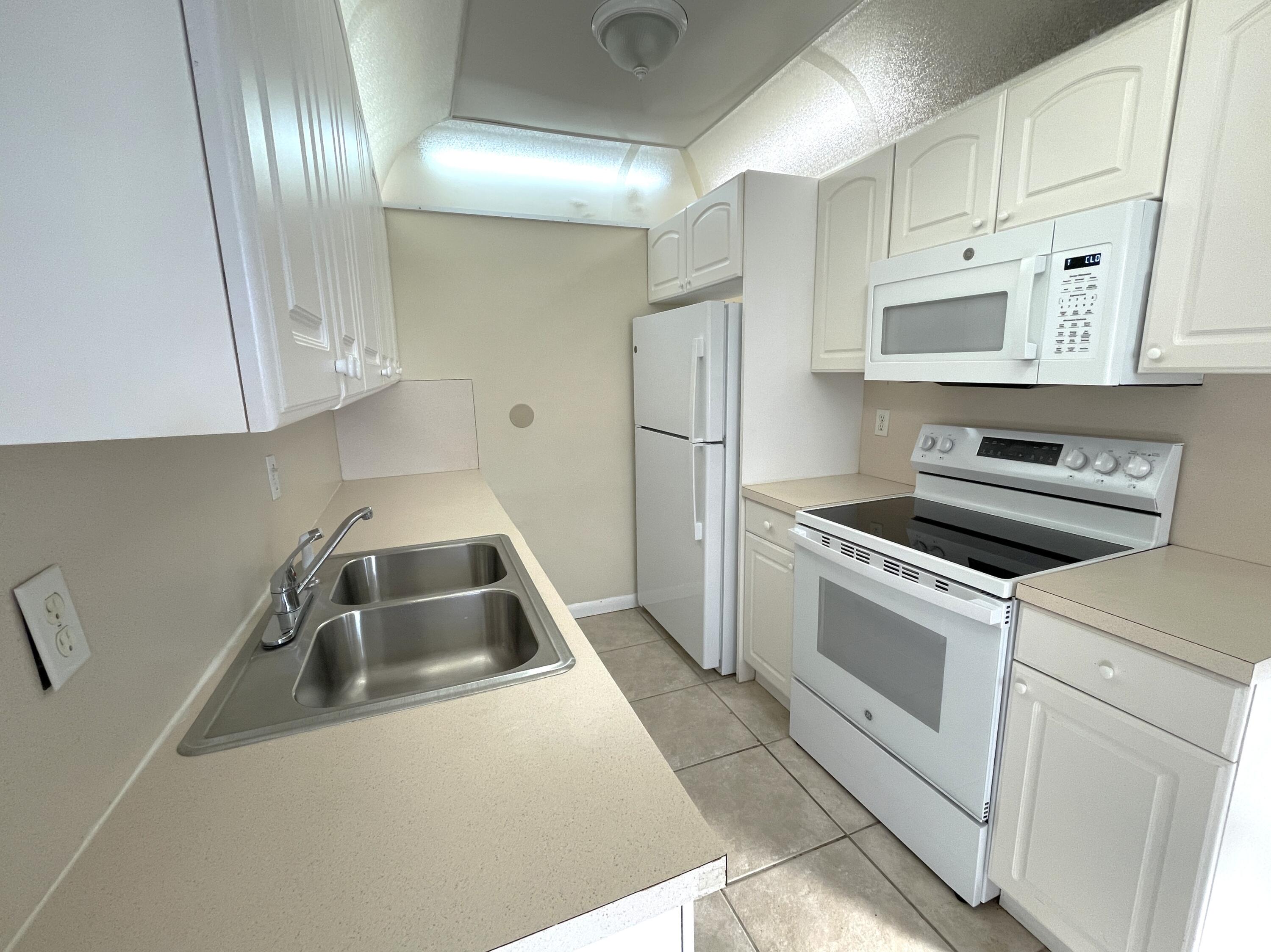 1020 Exeter, Unit 1020 Boca Raton, FL 33434 - Photo 7 of 29 a kitchen that has a sink and a stove