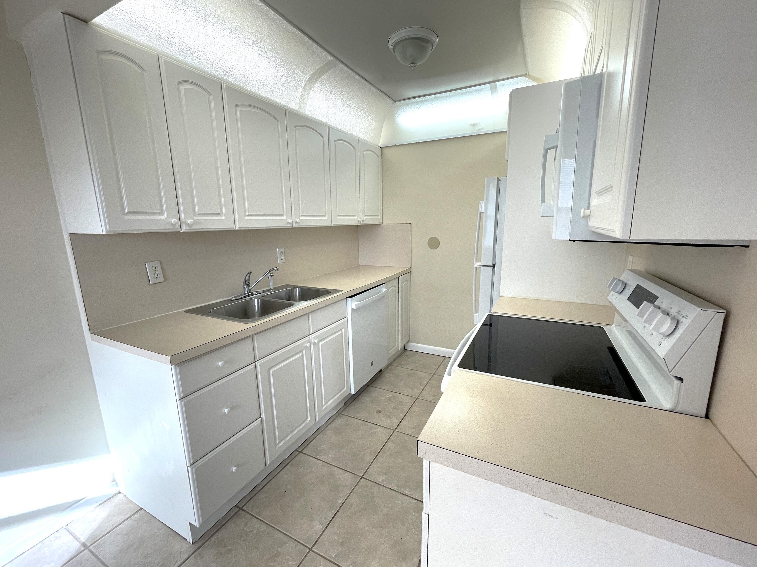 1020 Exeter, Unit 1020 Boca Raton, FL 33434 - Photo 8 of 29 a kitchen with a cabinets and white appliances
