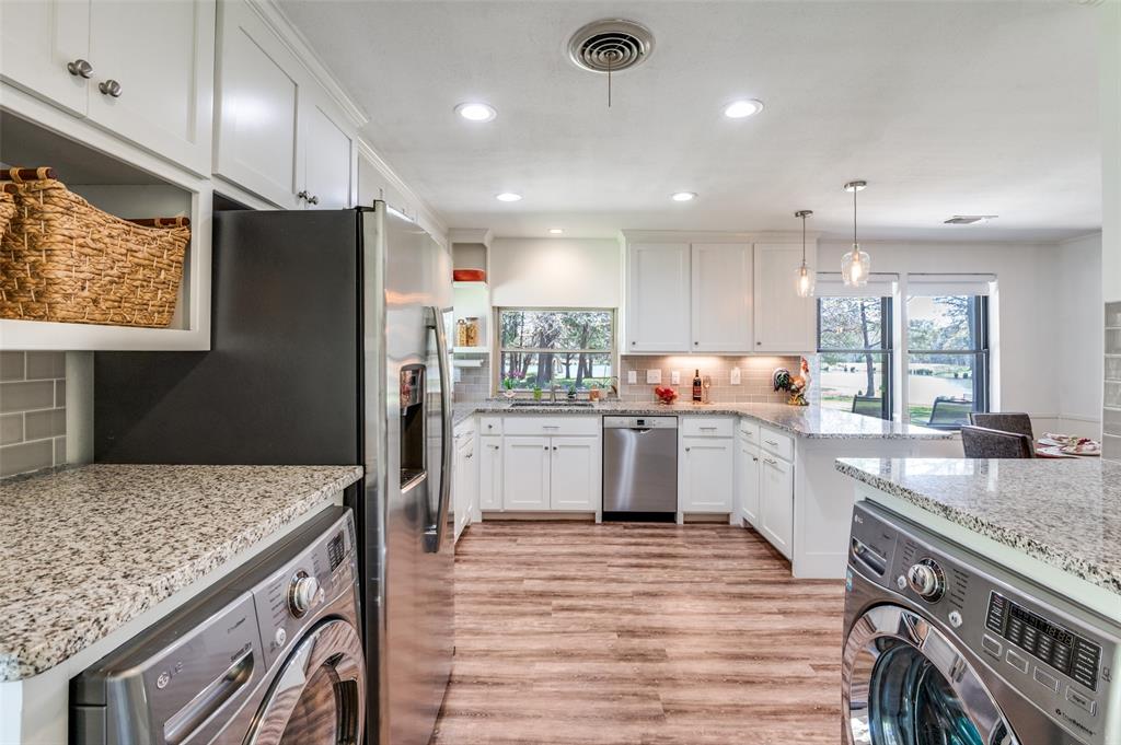182 Huts Crossing Sadler, TX 76264 - Photo 15 of 40 a kitchen with stainless steel appliances granite countertop a refrigerator a sink dishwasher a stove and white countertops with wooden floor