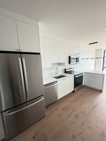 a kitchen with white cabinets and white appliances