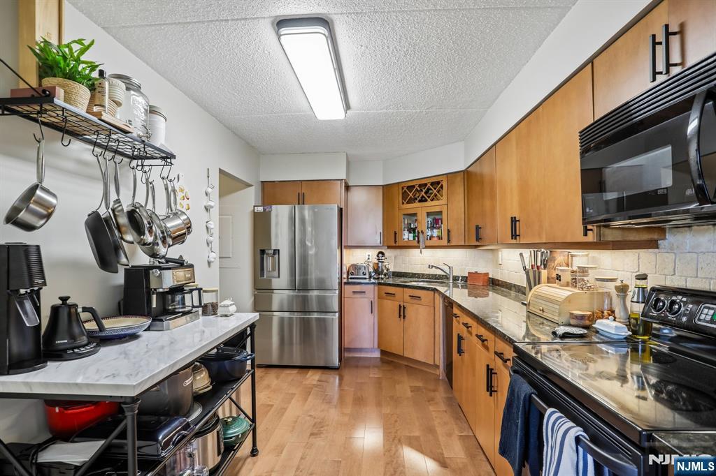 1077 River Road, Unit 303 Edgewater, NJ 07020 - Photo 11 of 27 a kitchen with stainless steel appliances granite countertop a sink stove and refrigerator