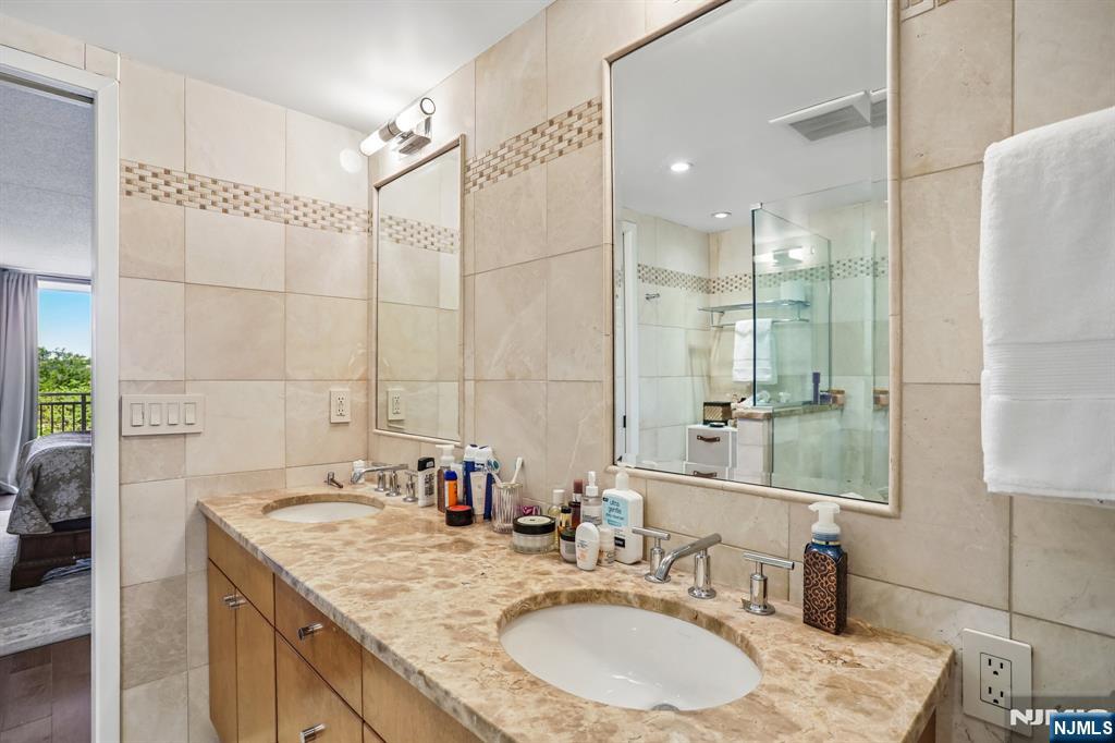 1077 River Road, Unit 303 Edgewater, NJ 07020 - Photo 18 of 27 a bathroom with a granite countertop sink mirror and a shower