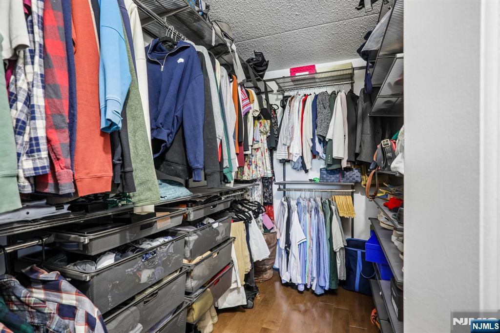 1077 River Road, Unit 303 Edgewater, NJ 07020 - Photo 19 of 27 a view of walk in closet with clothes
