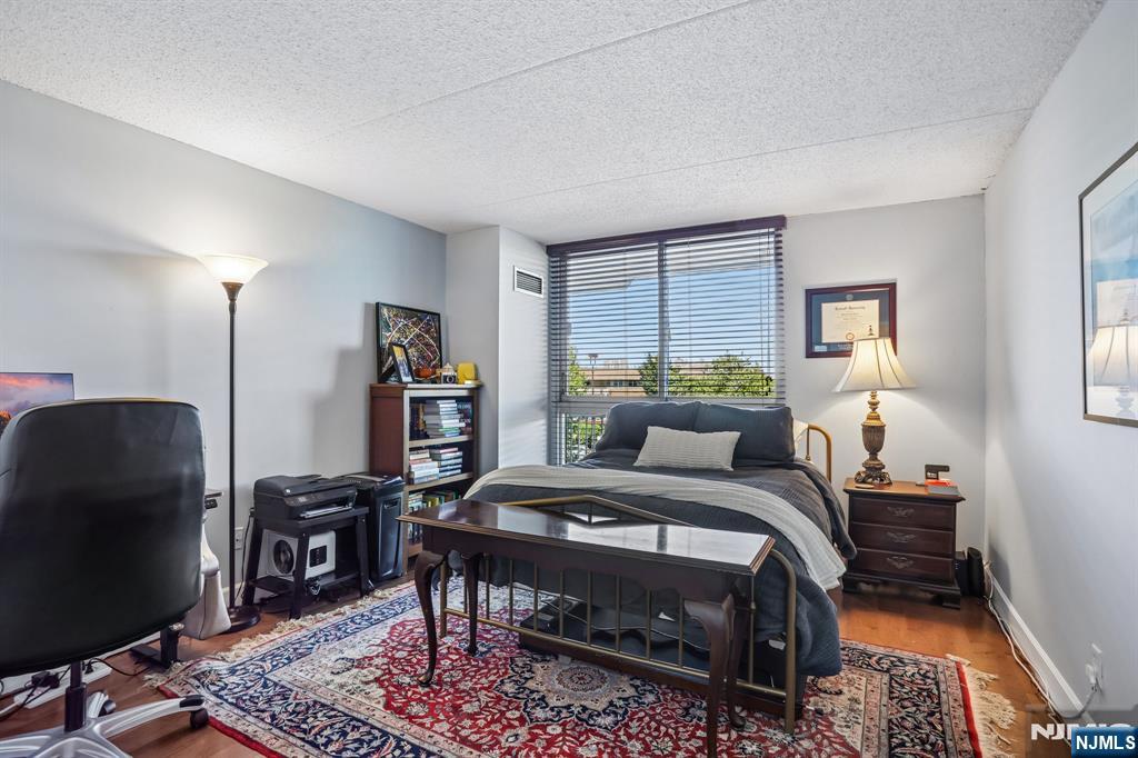 1077 River Road, Unit 303 Edgewater, NJ 07020 - Photo 20 of 27 a bedroom with a bed a desk and chair