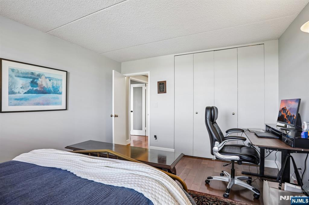 1077 River Road, Unit 303 Edgewater, NJ 07020 - Photo 21 of 27 a bedroom with a bed and a desk